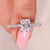 Radiant cut diamond ring with pave band and cathedral setting.