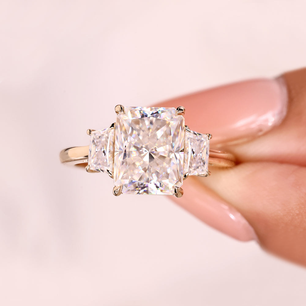 Modern radiant cut moissanite three stone ring.
