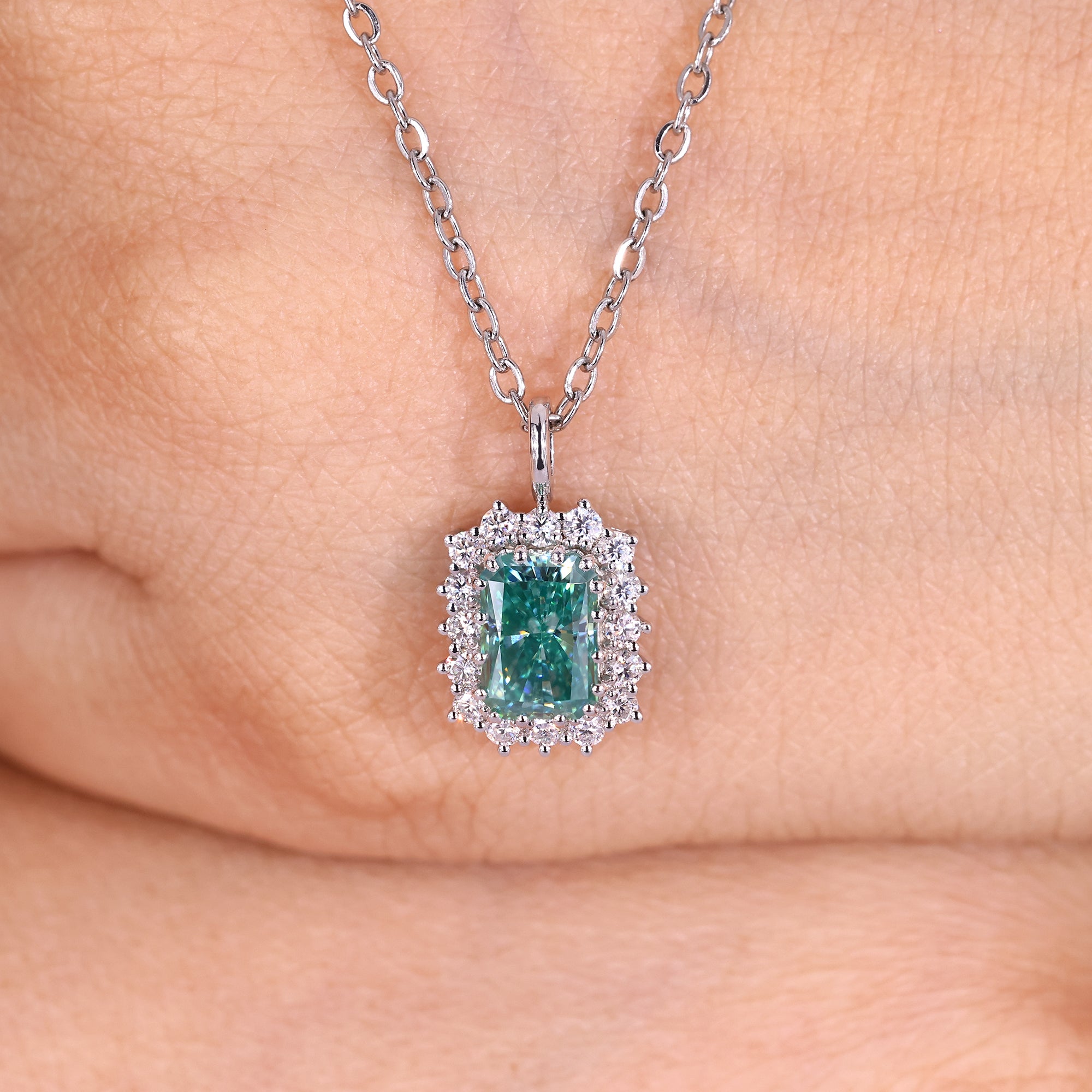 Radiant cut cyan blue moissanite halo pendant.
