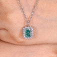 Radiant cut cyan blue moissanite halo pendant.
