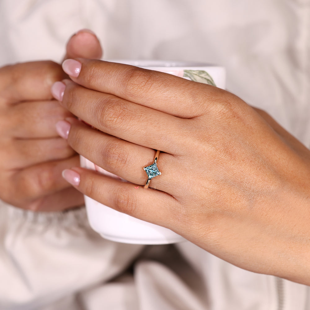 Cyan blue moissanite ring with four v prong set.
