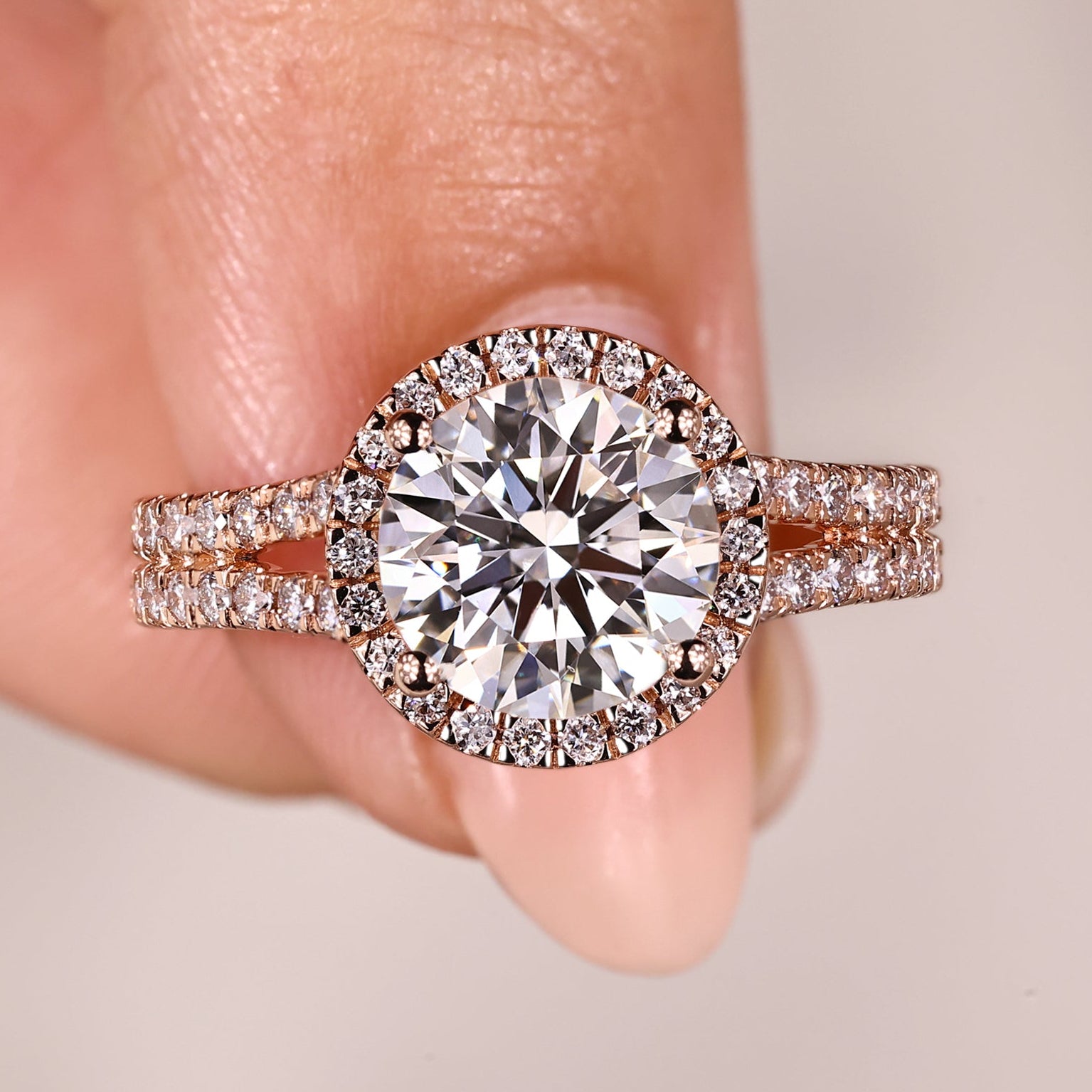 Round cut diamond ring with halo and split pave band.
