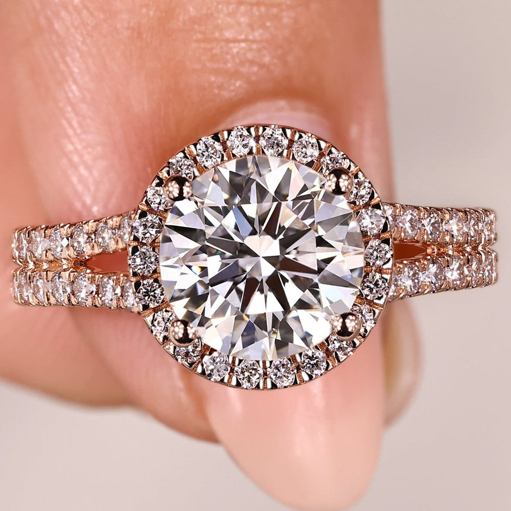 Round cut diamond ring with halo and split pave band.
