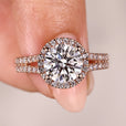 Round cut diamond ring with halo and split pave band.
