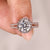 Round cut diamond ring with halo and split pave band.
