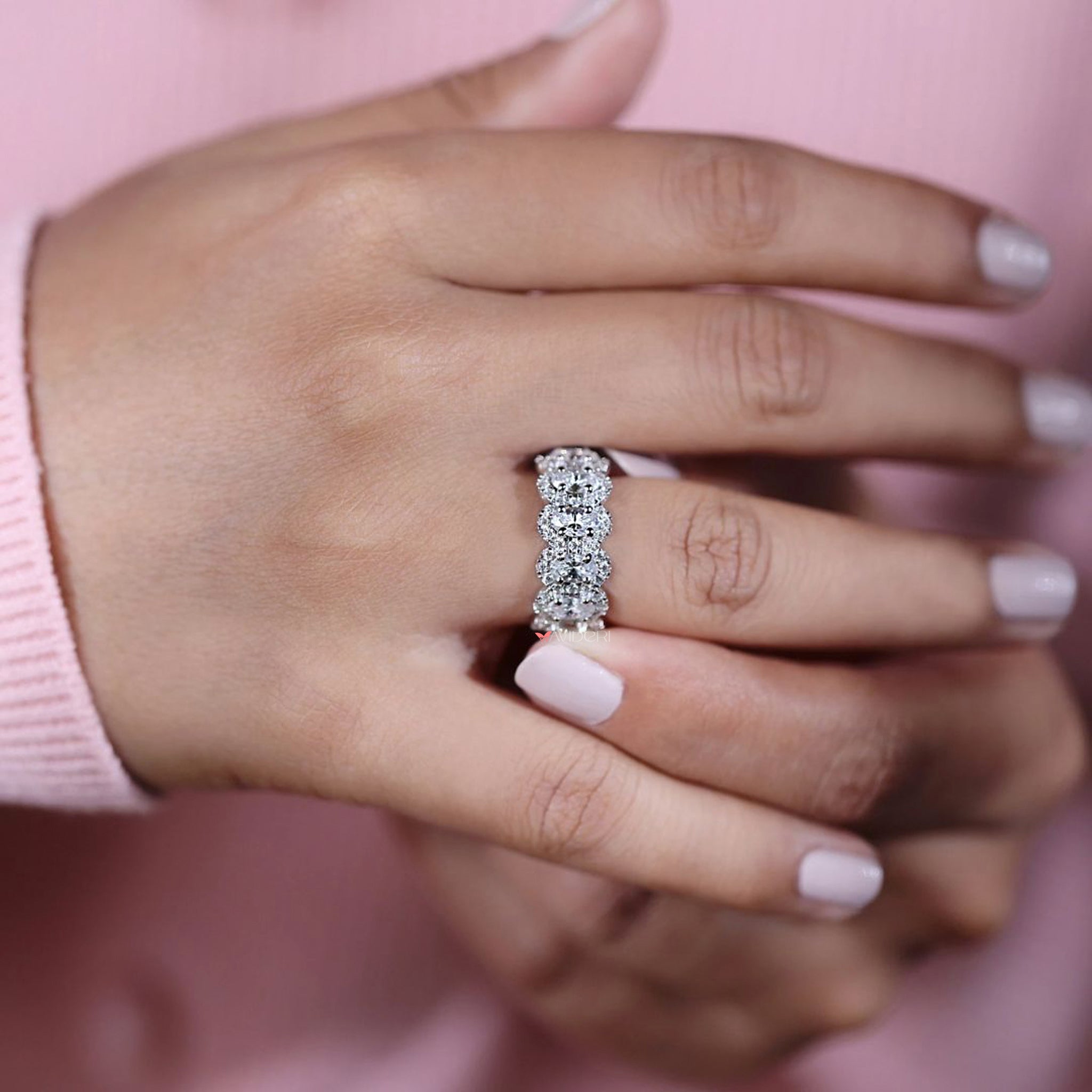 Oval cut wedding band with round moissanite halo accents.