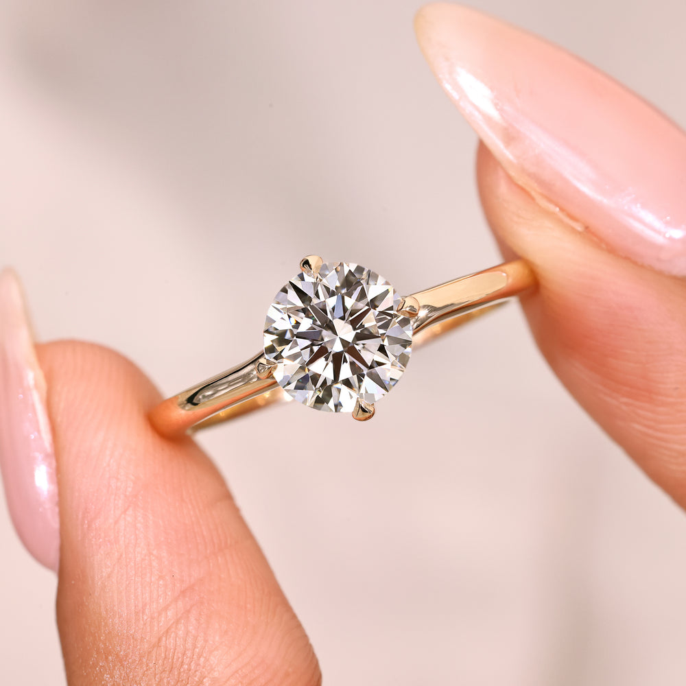 Lab grown round diamond ring with four claw prongs.
