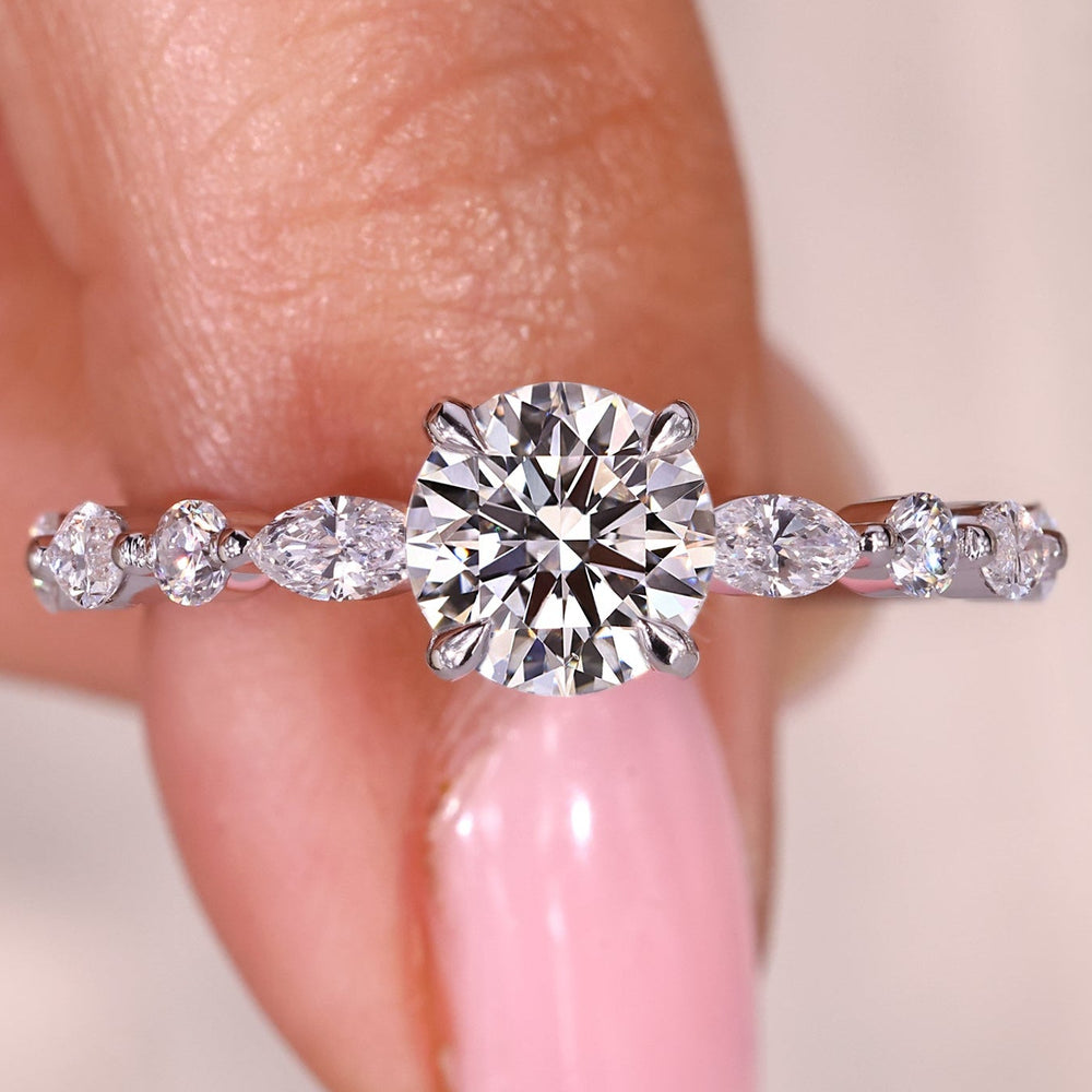 Round diamond engagement ring with marquise side stones.
