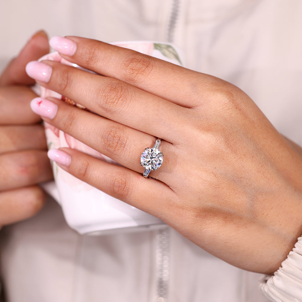 Three stone round moissanite ring with tapered baguettes.
