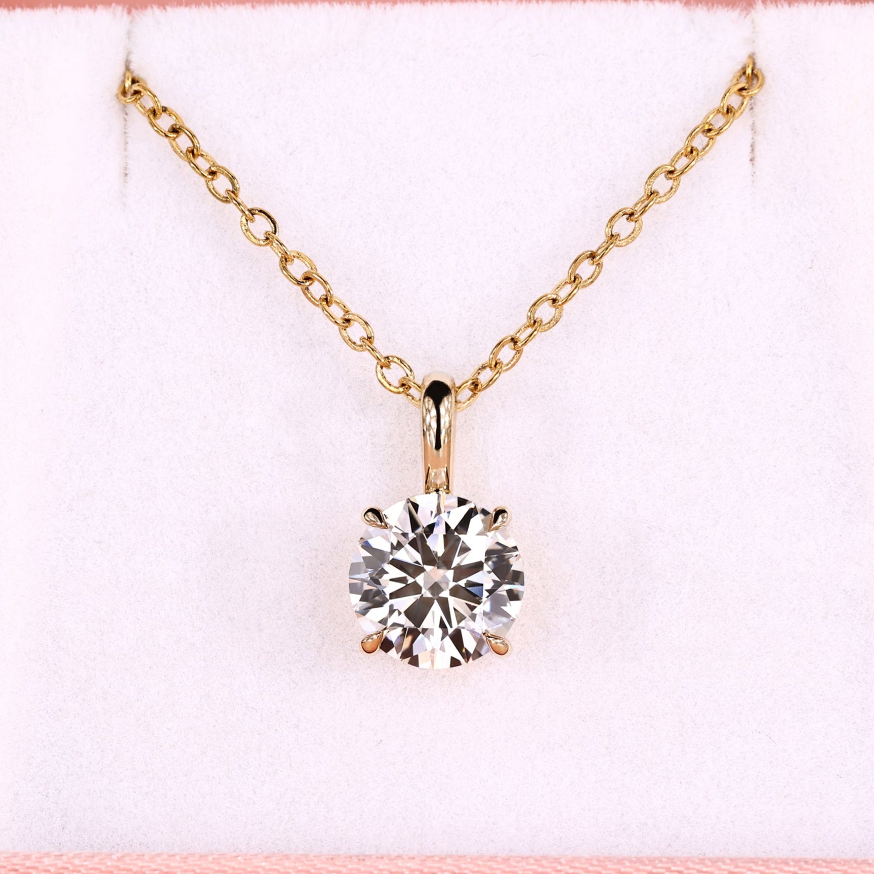 Round solitaire pendant with four claw prong setting in yellow gold.