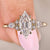 Hexagon step cut diamond ring with marquise side stones
