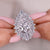 Diamond ring held between fingers with a blurred background