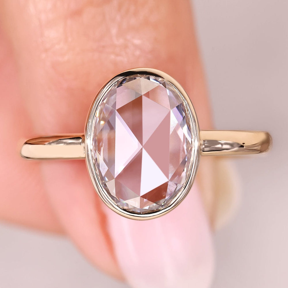 Oval rose cut solitaire diamond ring in bezel style.
