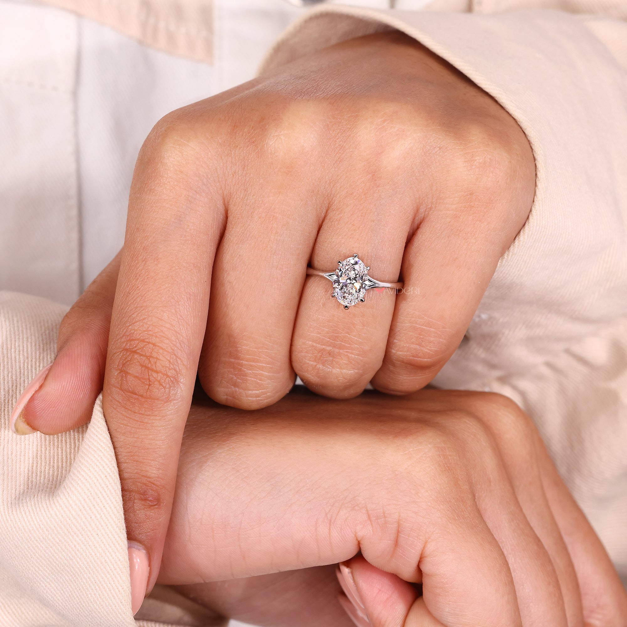 Oval diamond ring with split shank and solitaire style.
