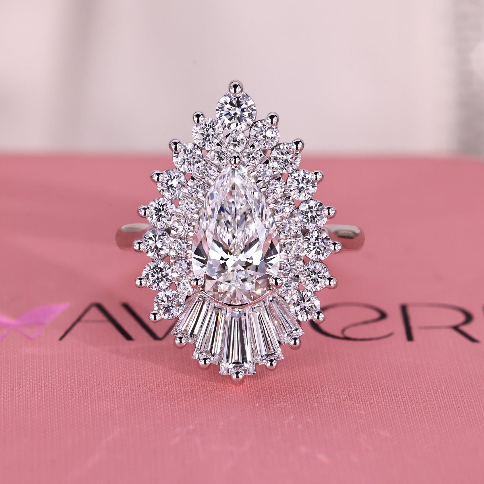 Diamond ring on a pink surface with an Avideri ring box