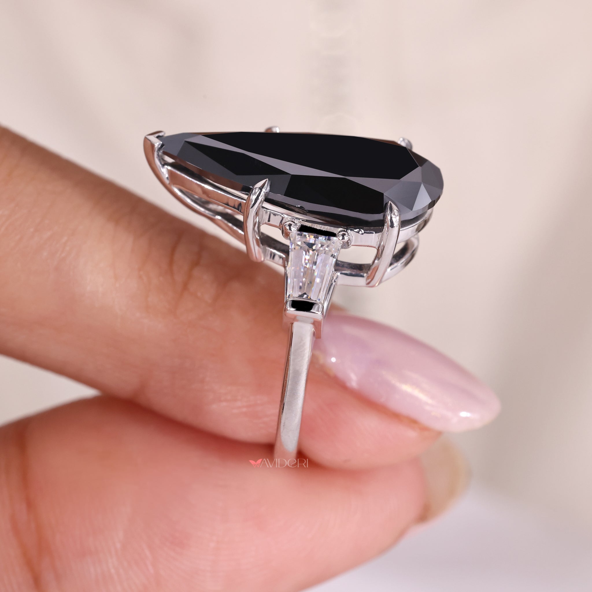 three stone moissanite engagement ring with tapered baguette side stones in white gold.