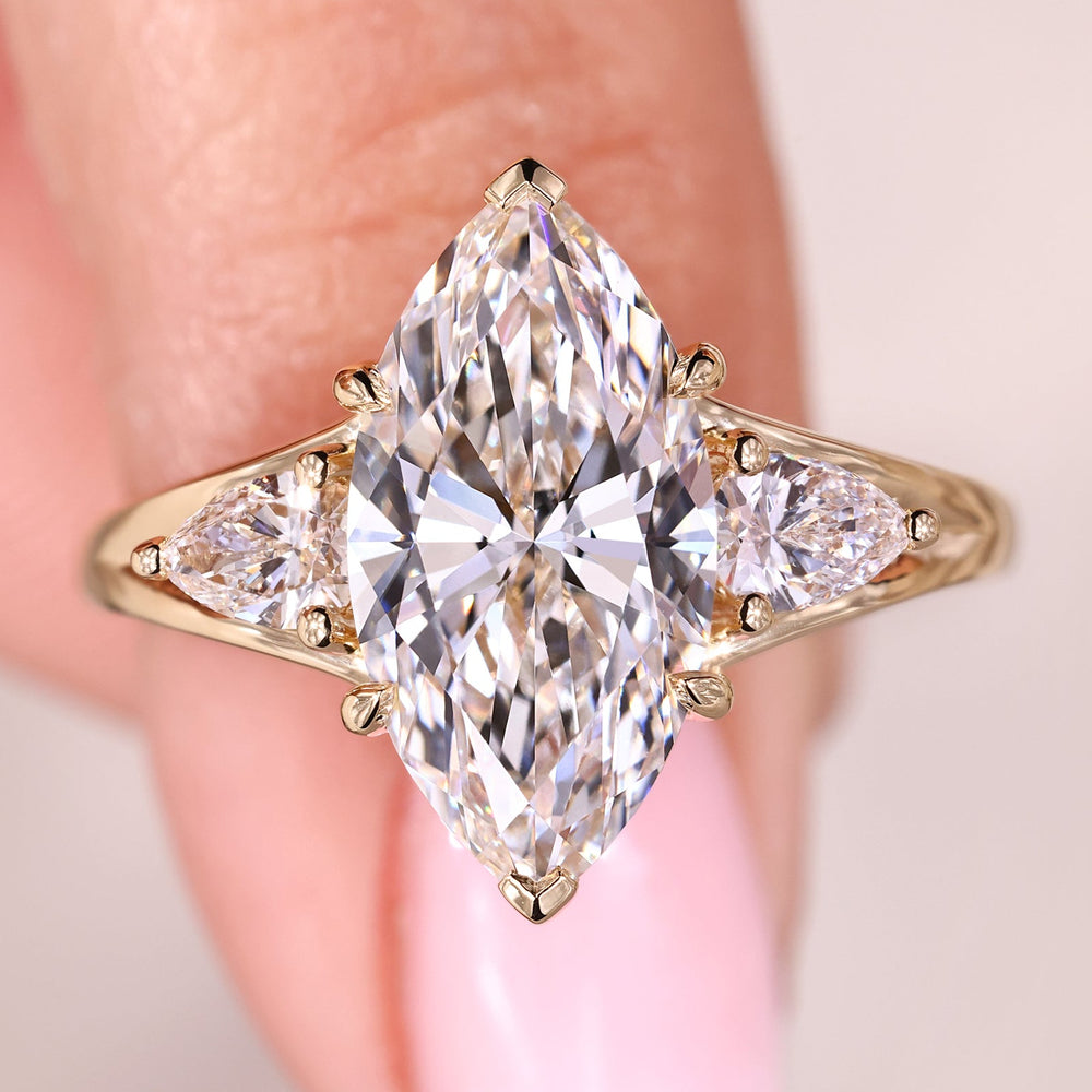 Three stone marquise diamond ring in yellow gold.