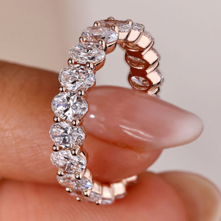 A stunning oval diamond eternity band with a sleek design, perfect for a timeless wedding look.
