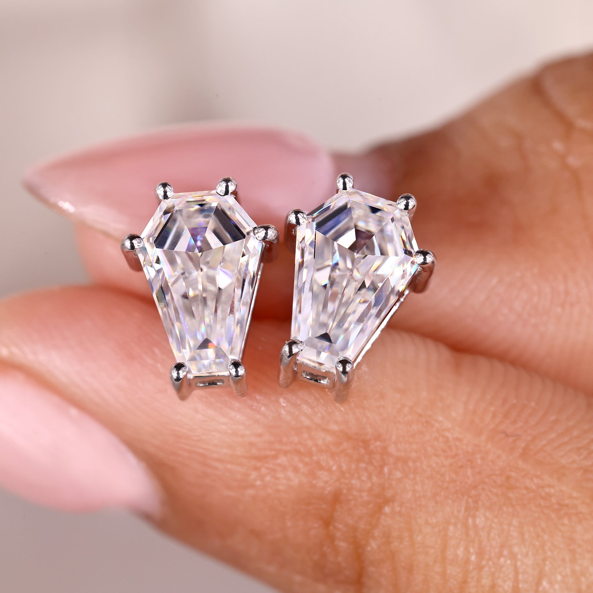 Moissanite stud earrings in elegant white gold prong settings.