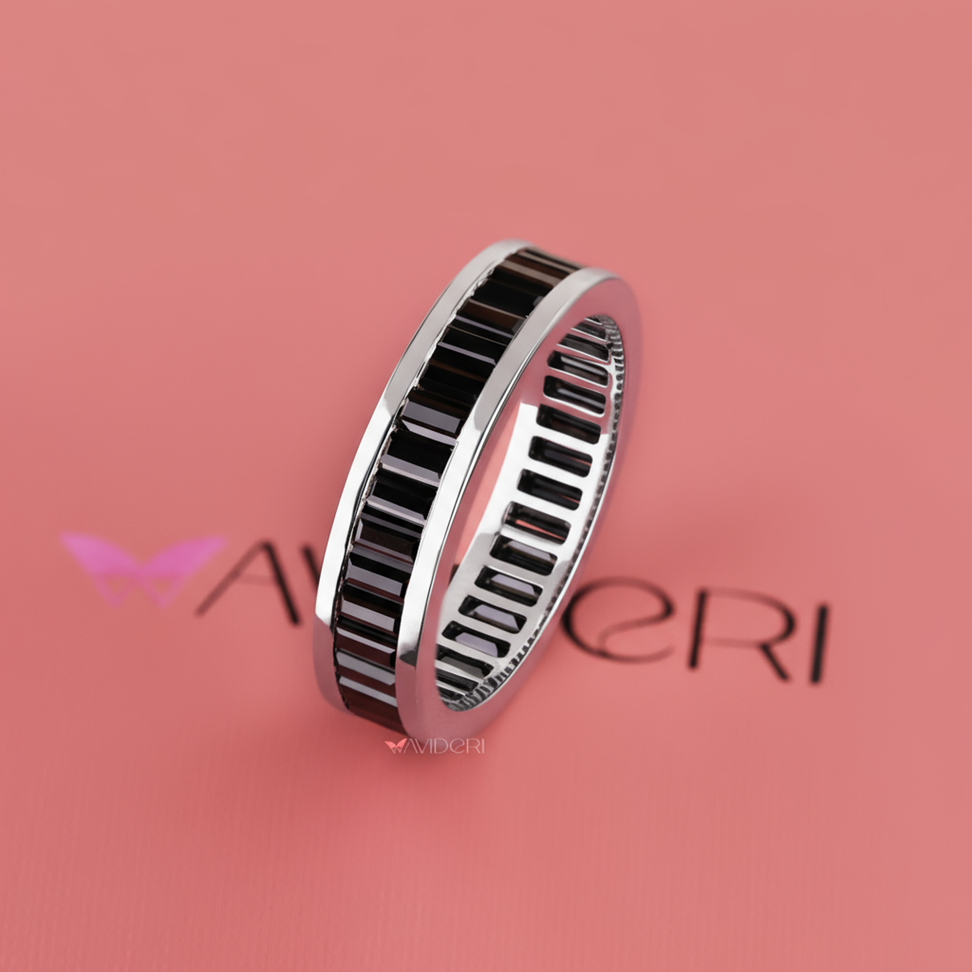 Silver ring with black accents on a pink background with 'Aureli' branding.