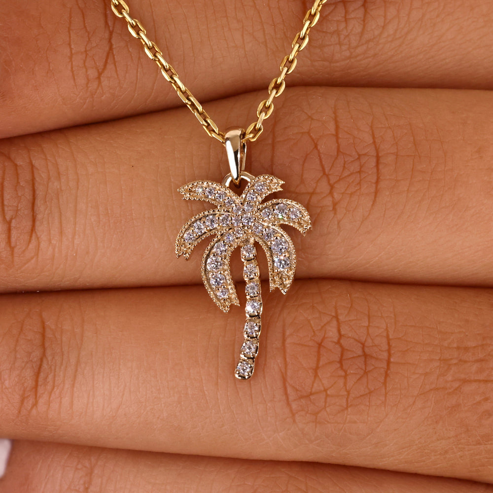 Gold palm tree pendant featuring intricate details.
