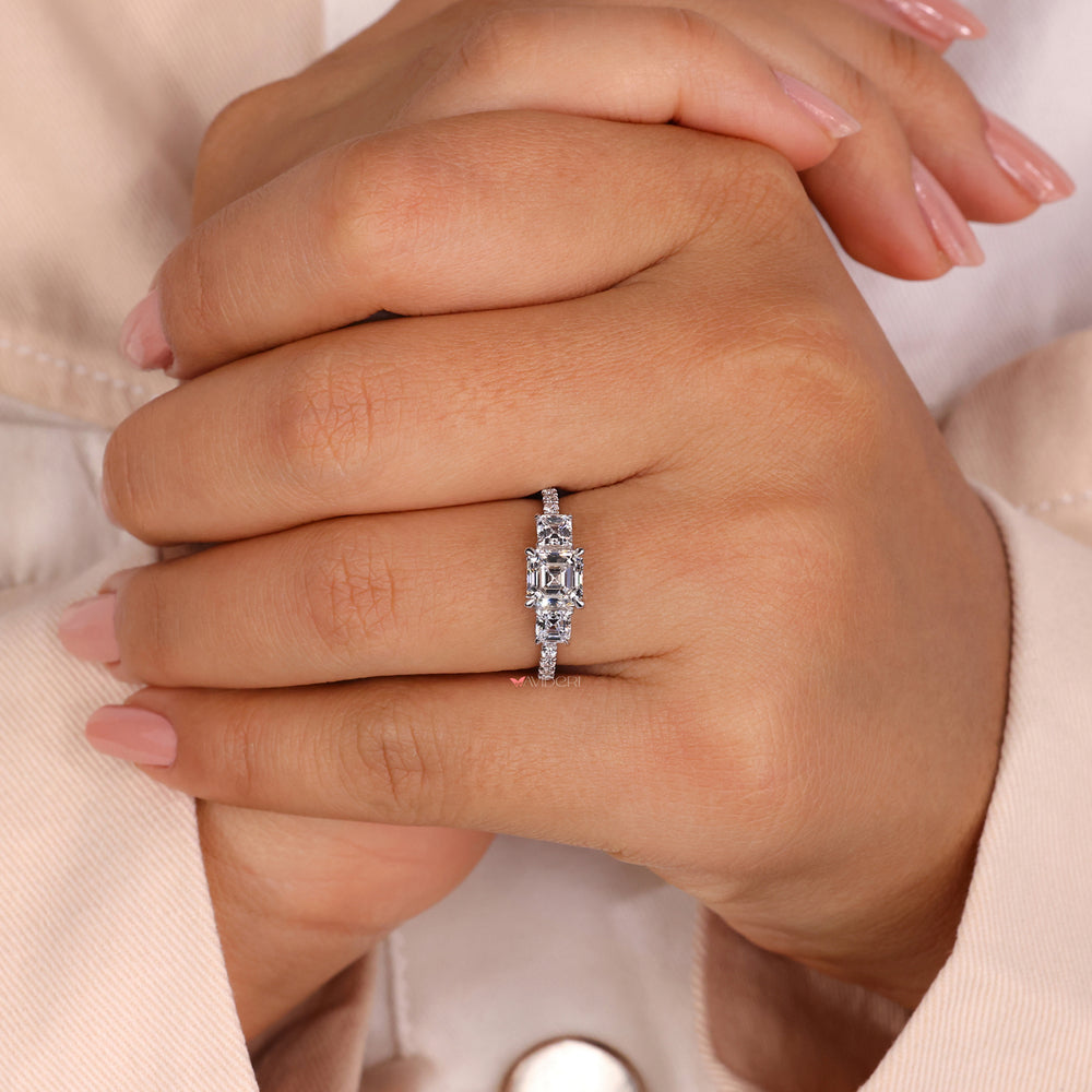 Asscher engagement ring with a three stone engagement ring.
