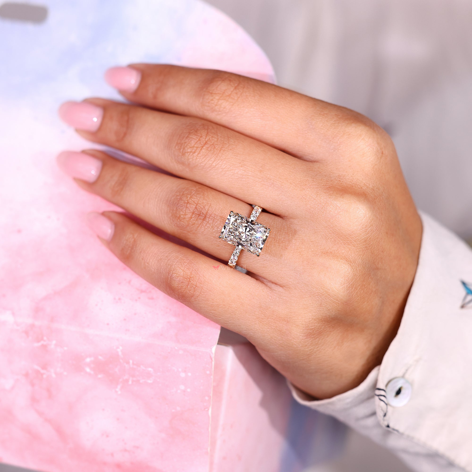 Radiant cut diamond ring with hidden halo and pave band.
