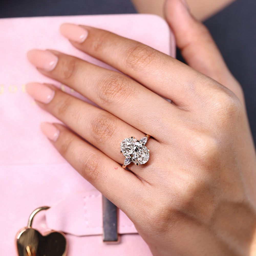 Three stone oval diamond ring with pear accents.
