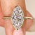 Marquise cut diamond ring with bezel setting.
