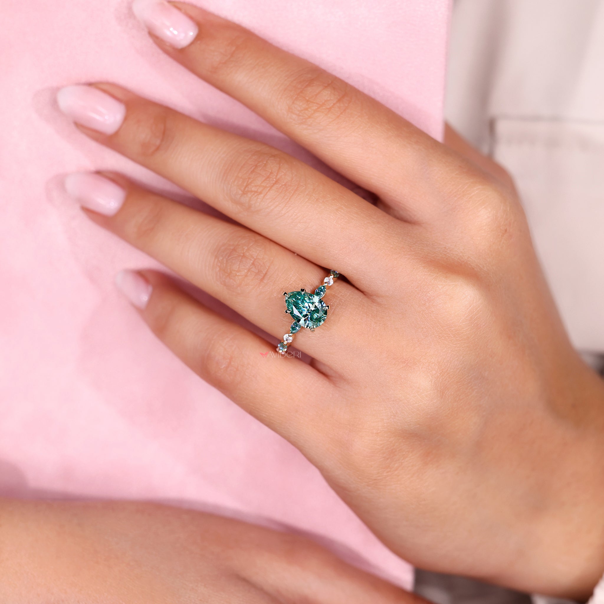 Cyan blue moissanite ring with side stones.
