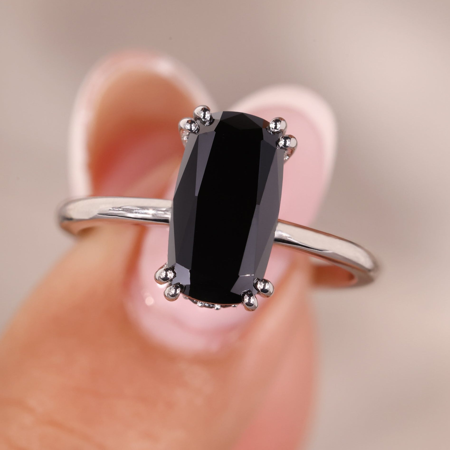 Elongated cushion cut engagement ring placed in a delicate solitaire design.
