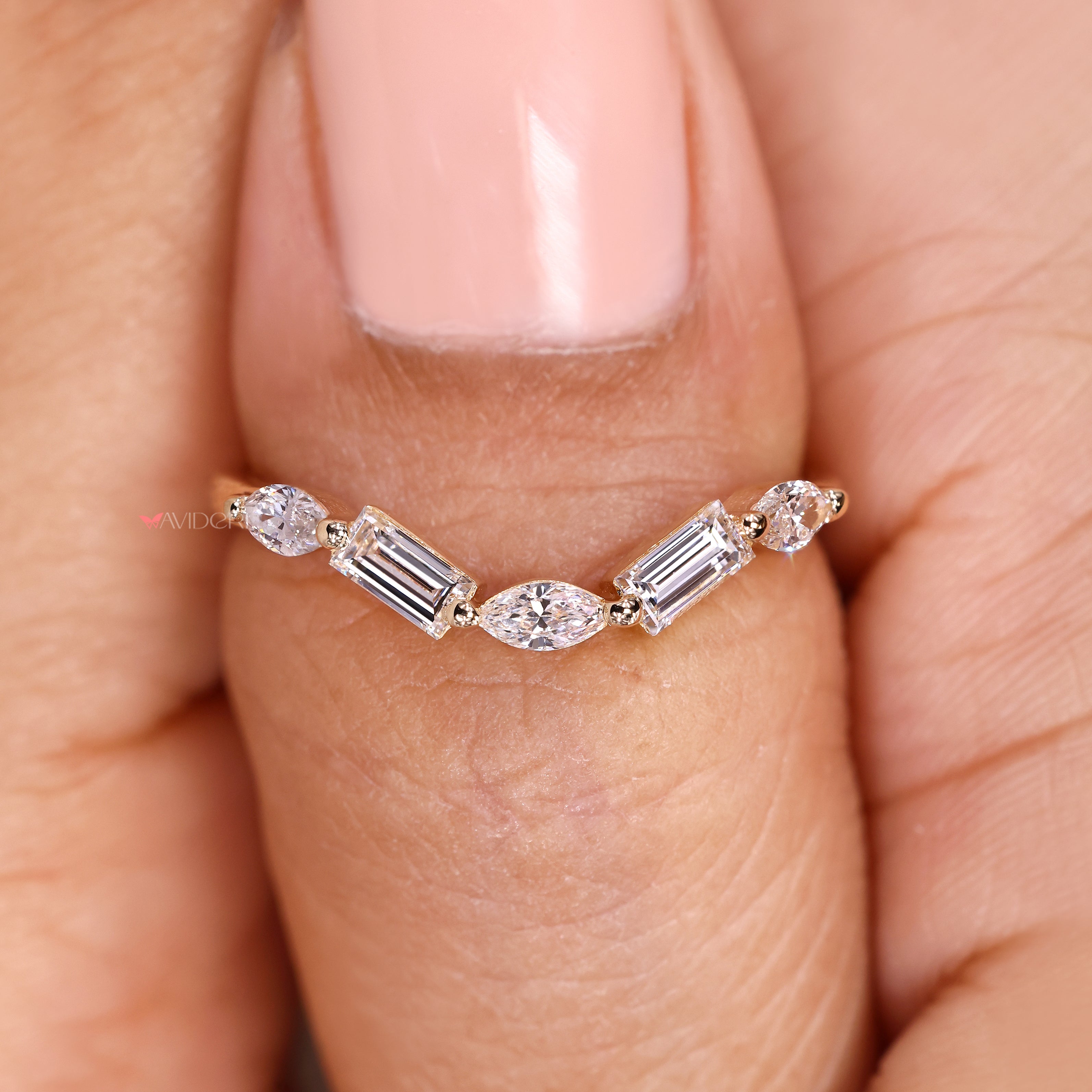 Curved wedding ring with marquise and baguette diamond details.
