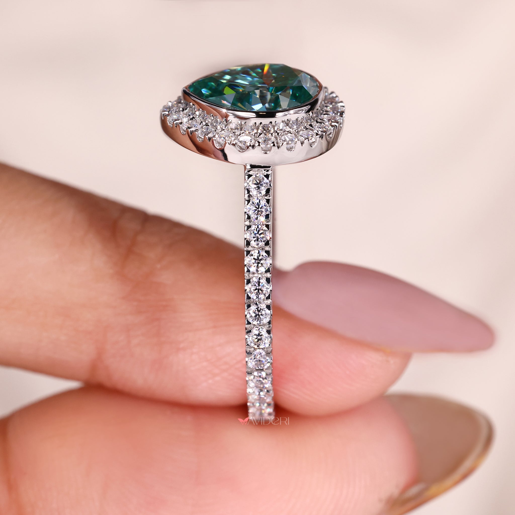 Pave setting ring with a pear cut diamond in a gold design.