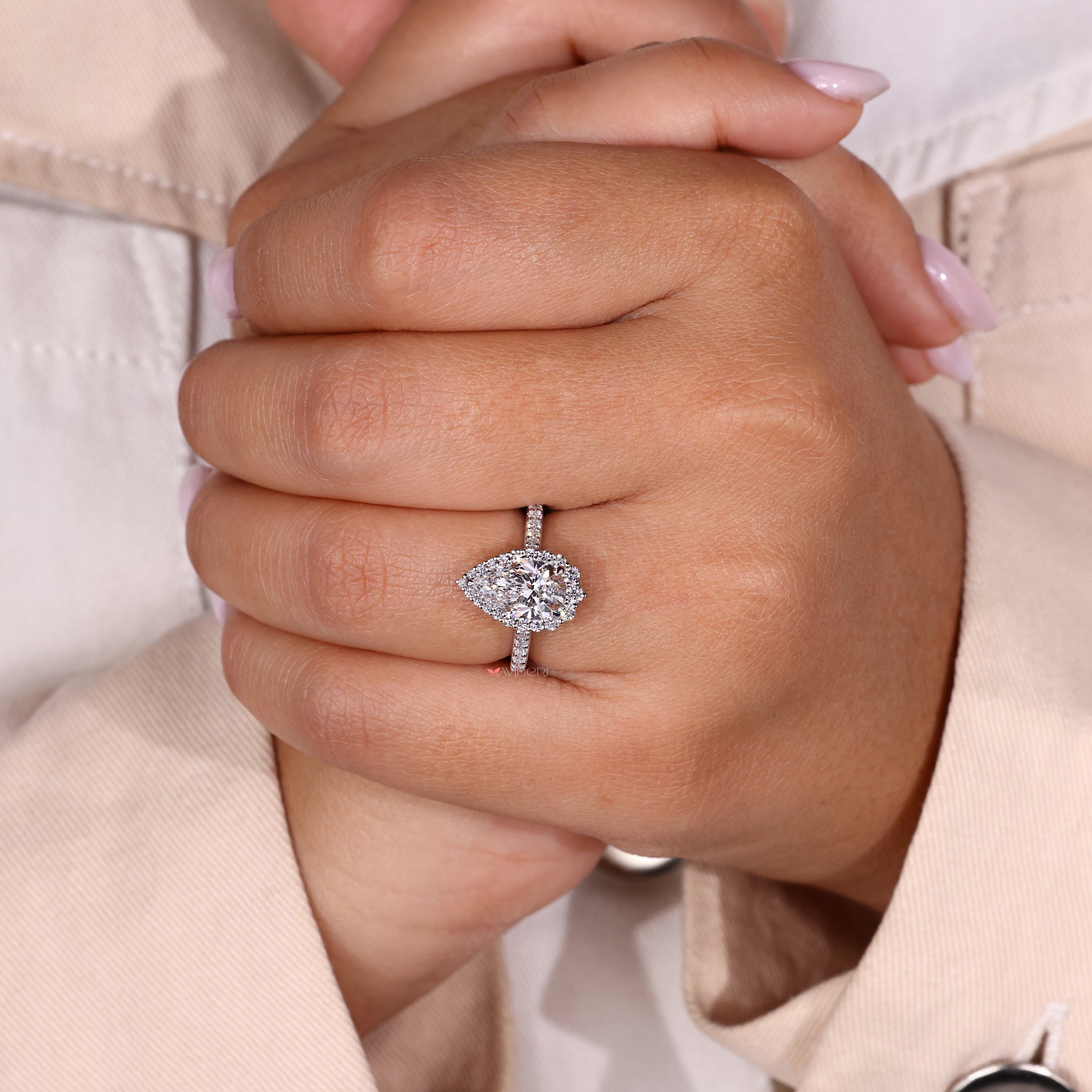 Claw prong ring with a halo design and a stunning pear shaped diamond centerpiece.
