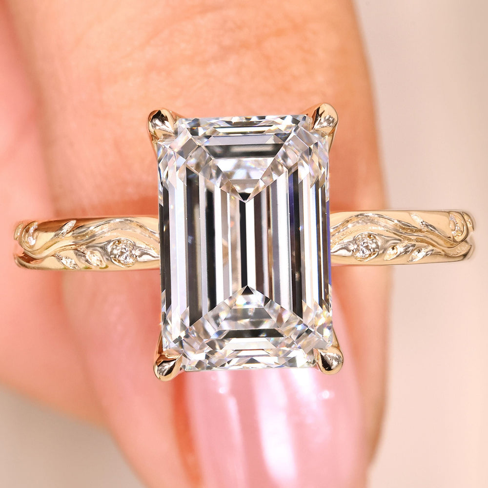 Emerald cut diamond ring with round side stones.
