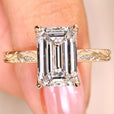 Emerald cut diamond ring with round side stones.
