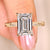 Emerald cut diamond ring with round side stones.
