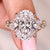 Oval cut diamond ring with marquise and round side stones.
