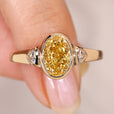 Oval cut yellow diamond ring with trillion sides.
