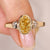 Oval cut yellow diamond ring with trillion sides.
