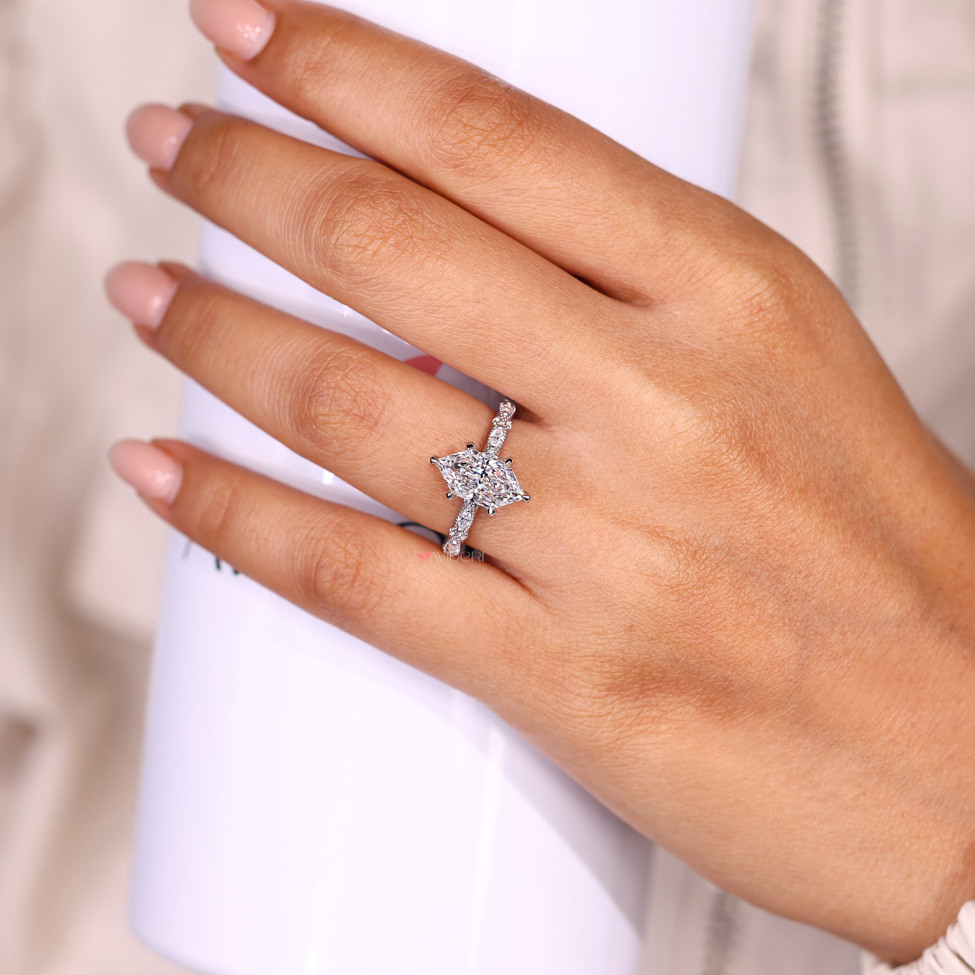 Marquise diamond ring with round side stones and milgrain.
