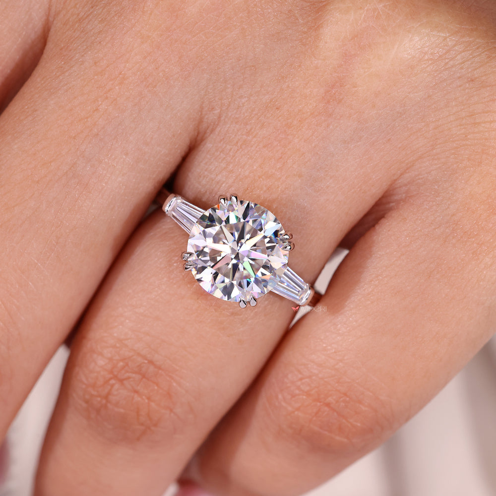 Round moissanite ring with baguette side stone accents.
