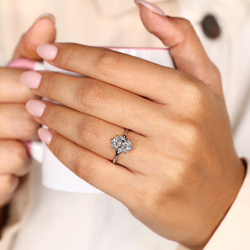 Solitaire oval diamond ring with six claw prongs.
