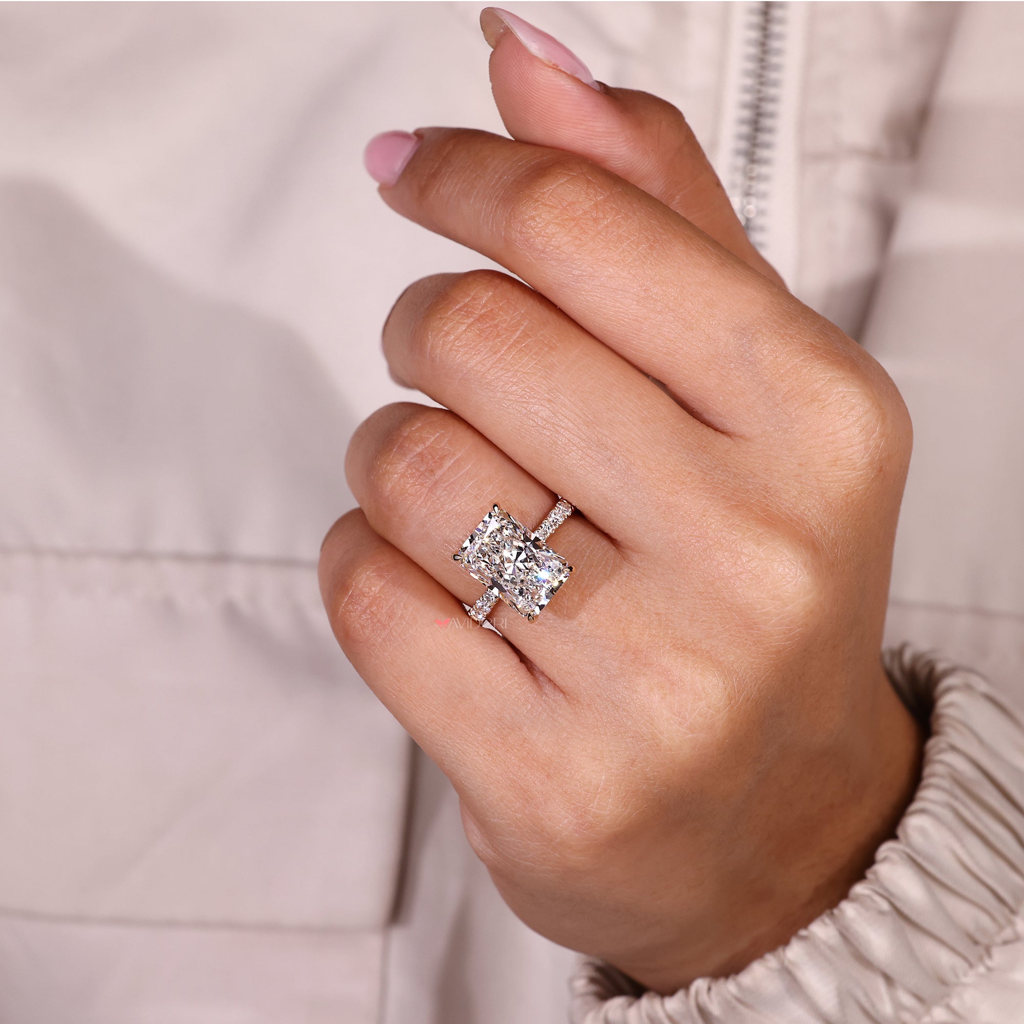 Radiant cut diamond ring with round diamond pave band.
