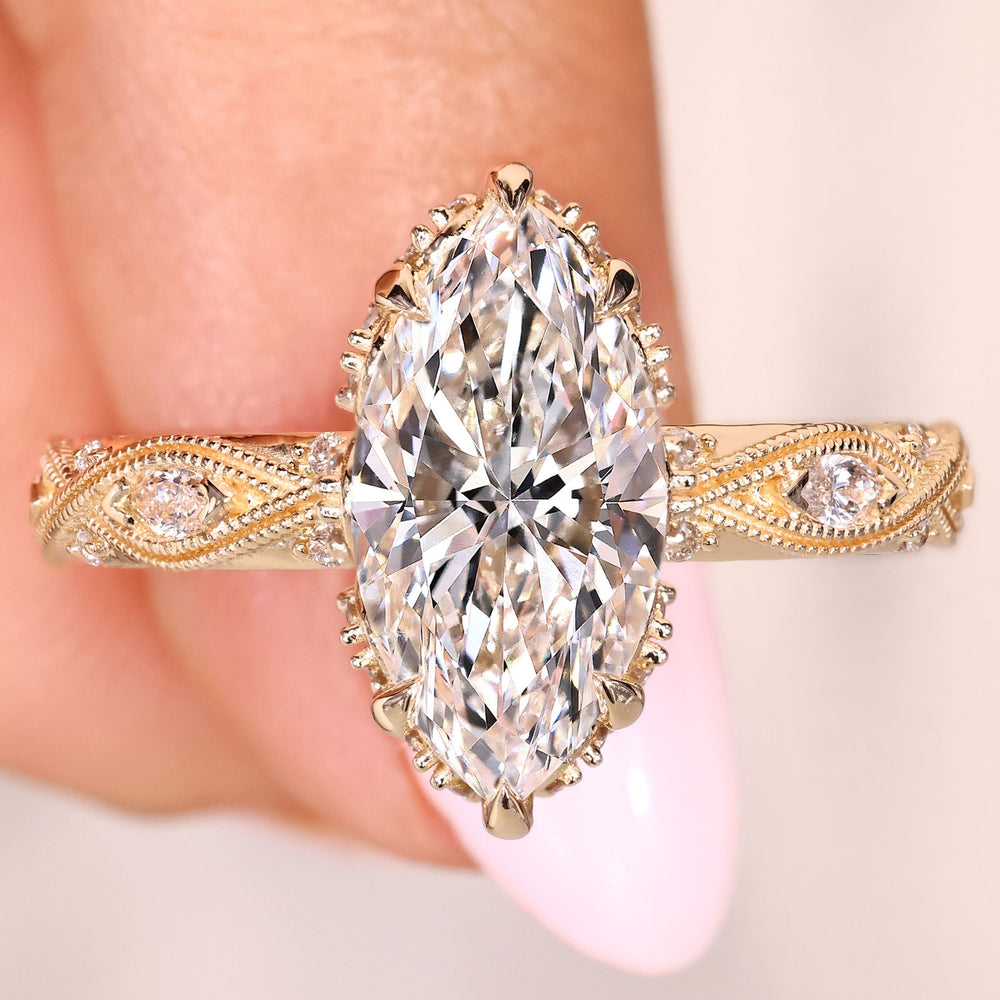 Marquise engagement ring with round side stones and hidden halo
