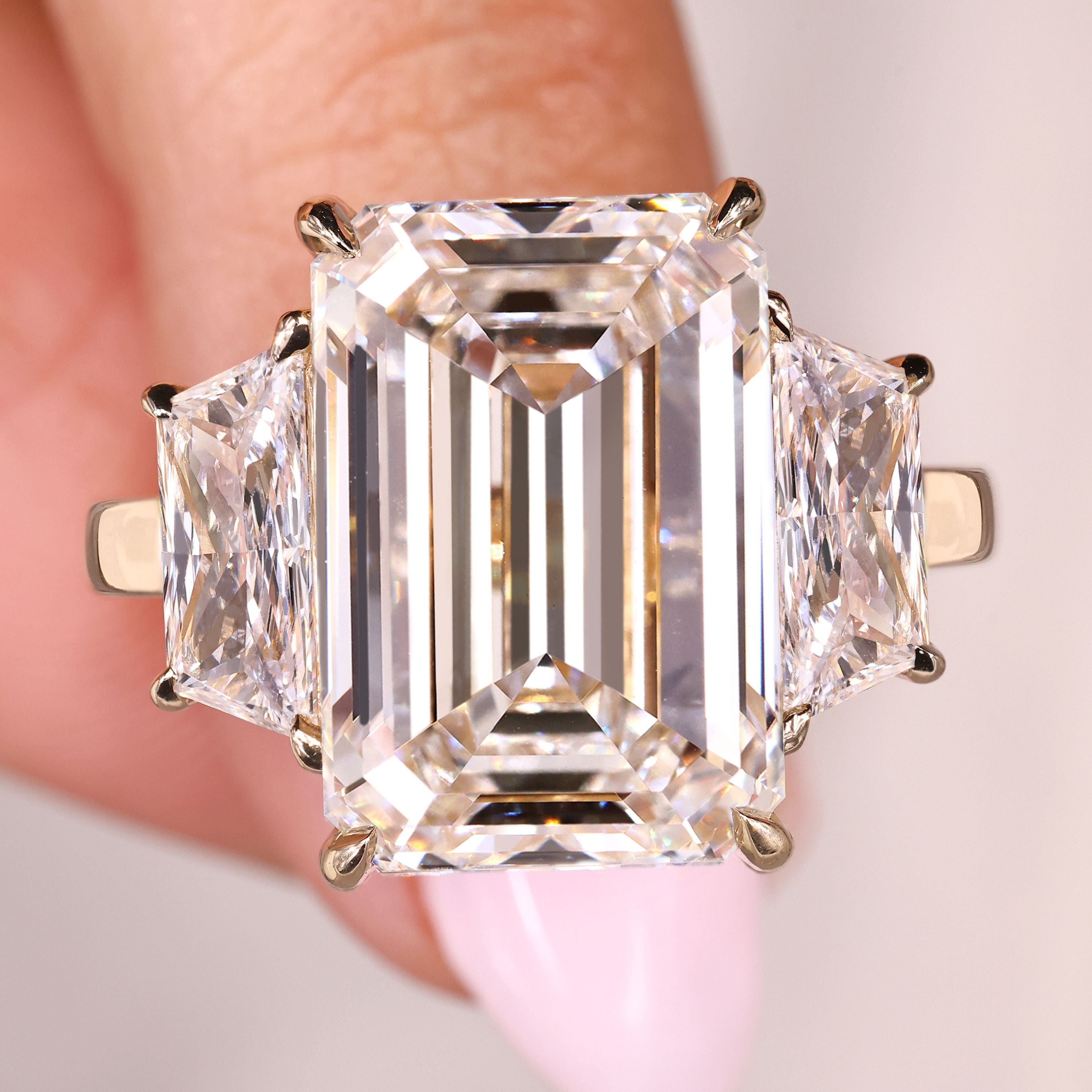 Emerald cut engagement ring with trapezoid side stones design
