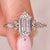 Hexagon step cut diamond ring with side stones.
