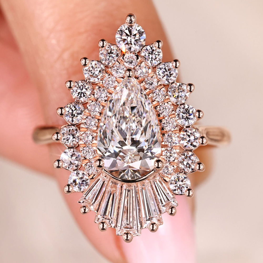 Pear cut diamond ring with tapered baguette and round halo.