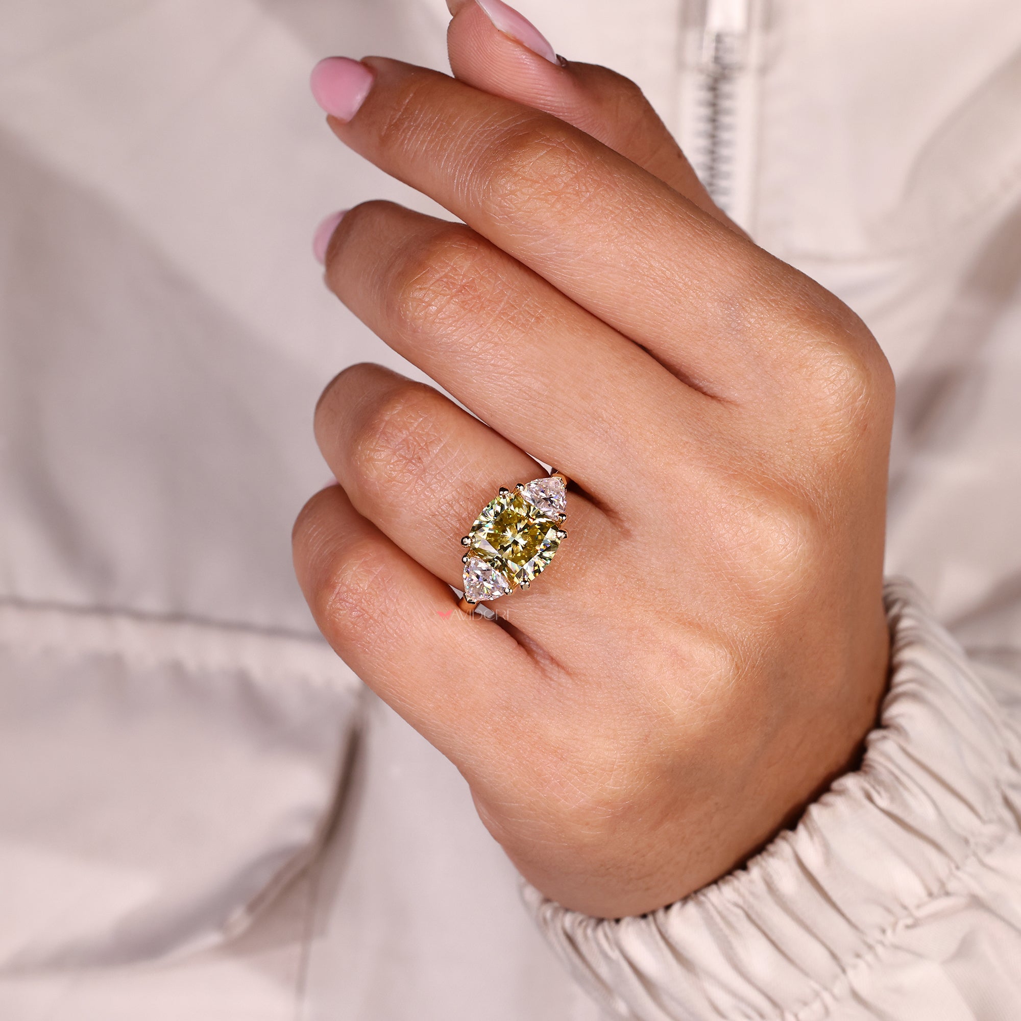 Three stone moissanite ring with bold yellow center stone.
