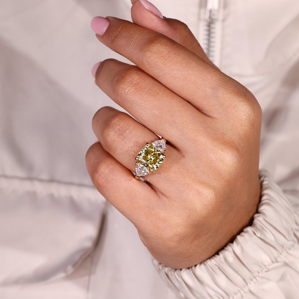 Three stone moissanite ring with bold yellow center stone.
